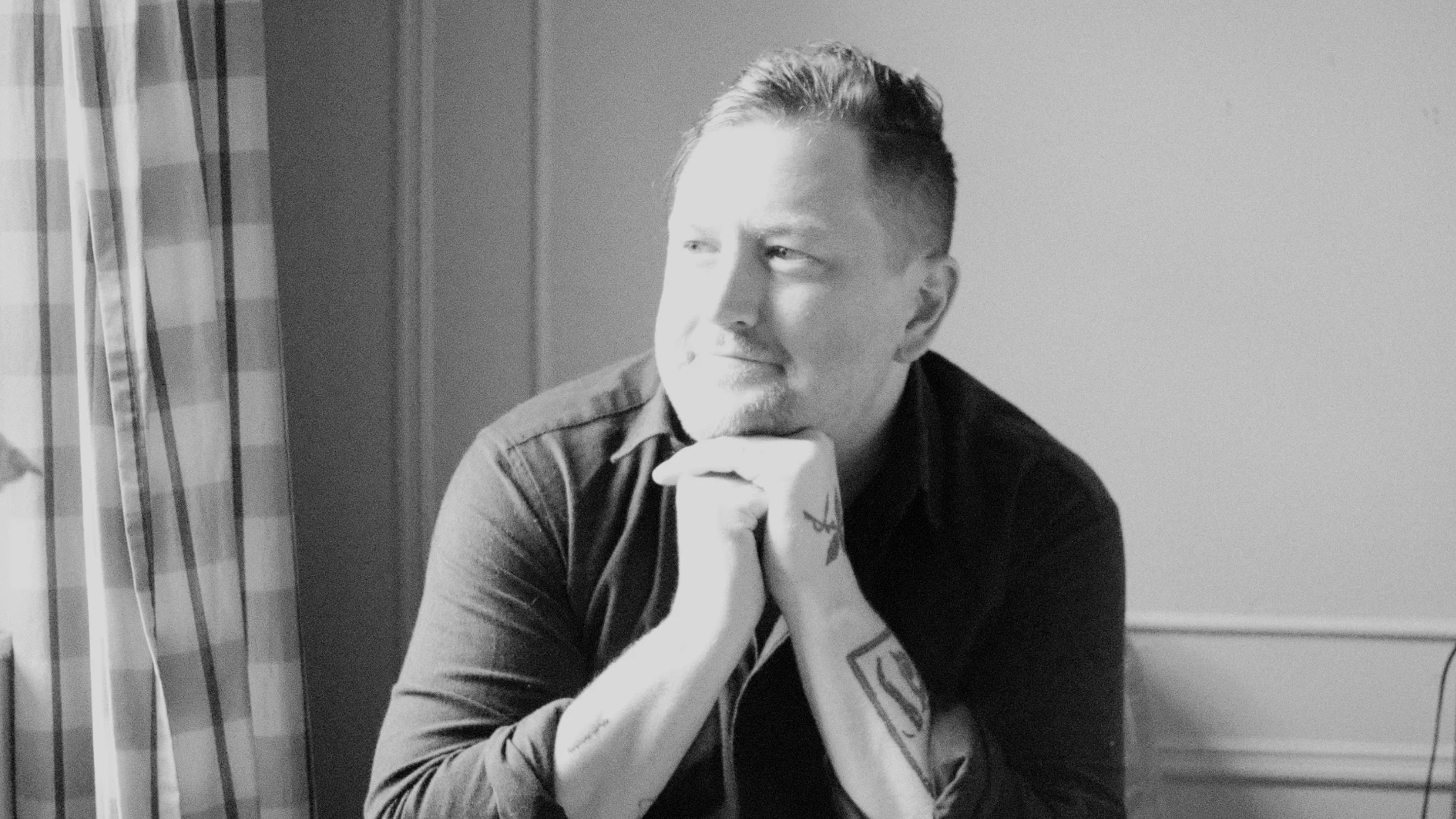 Griffin McCabe, seated by a window, chin resting on his hands